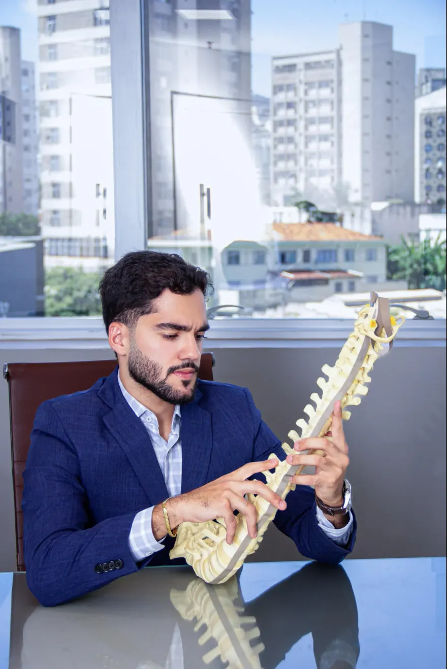 Dr. José Queiroz explicando a coluna com um modelo anatômico